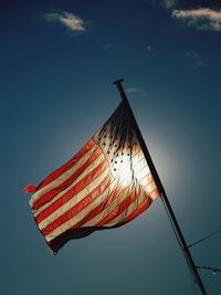 Low angle view of flag against blue sky