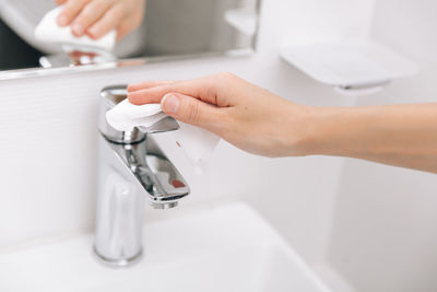 Cropped hand washing hands in sink