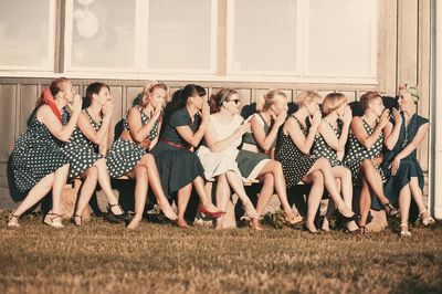 Friends relaxing on grassy field