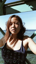 Portrait of beautiful woman standing in boat against sea