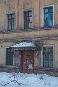 Abandoned building with snow covered window