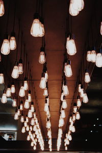 Low angle view of illuminated pendant lights hanging from ceiling