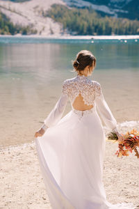 Rear view of woman with umbrella on beach