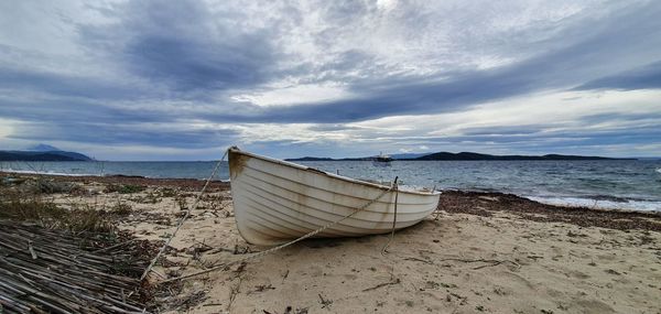 Deck chairs on beach against sky