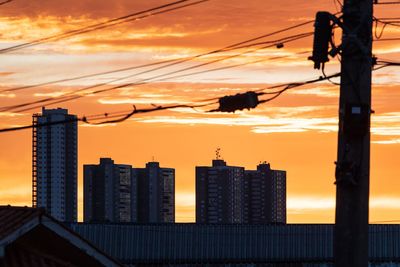 Silhouette buildings against sky during sunset