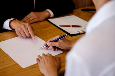 Midsection of male lawyer discussing with customer in office