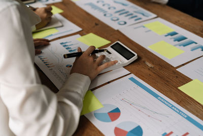 Midsection of business colleagues working on table