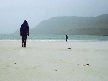 Rear view of two men on beach