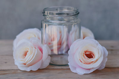 Close-up of white roses in jar on table