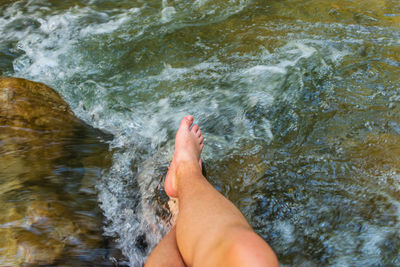 Low woman of person legs by flowing water