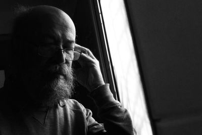 Man listening songs while sitting by window