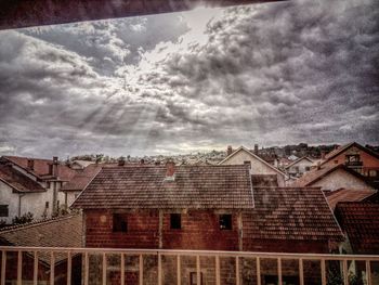 Houses in town against cloudy sky