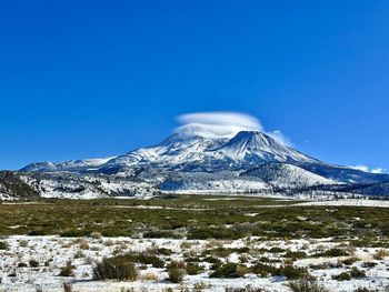 Scenic view of snowcapped mountains against clear blue sky