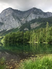 Scenic view of lake by mountains against sky