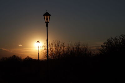 Silhouette street light against sky during sunset