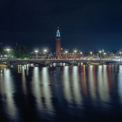 Illuminated bridge over river at night