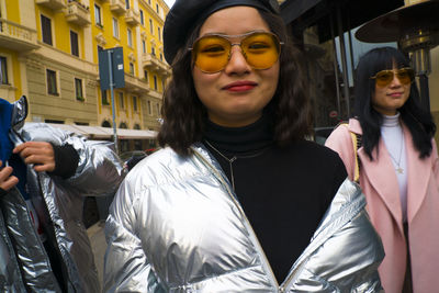 Portrait of young woman wearing sunglasses standing outdoors