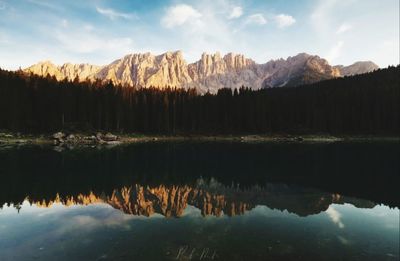 Scenic view of lake by mountain against sky