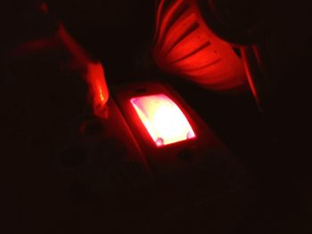 Close-up of illuminated red light on table in darkroom
