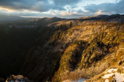 Scenic view of mountains against cloudy sky