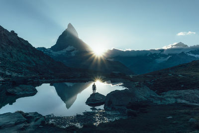 High angle view of man standing on rock in lake