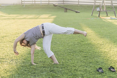 Young woman practicing cartwheel at playground