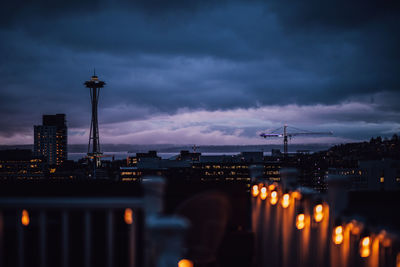 Dusk blue view of seattle skyline from rooftop deck with string lights