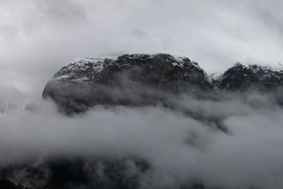 Low angle view of snow covered mountain against sky