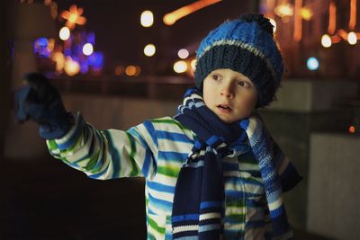 Boy in warm cloth standing outdoors at night