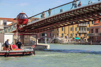 People walking on bridge over canal