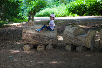 Full length of boy sitting on bench in park