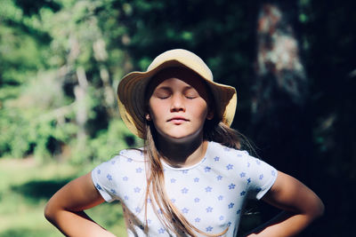 Portrait of teenage girl standing against trees