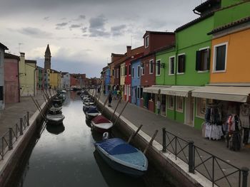 Boats moored in canal against buildings in city