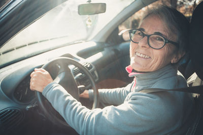 Portrait of smiling young woman sitting in car