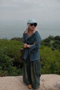 Rear view of woman standing on field against sky