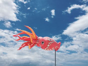 Low angle view of octopus shape windsock against sky