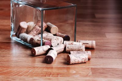 Wine corks in glass container on hardwood floor