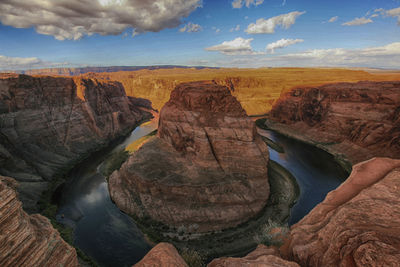 Scenic view of rock formations against cloudy sky