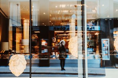 Reflection of woman on glass window in store