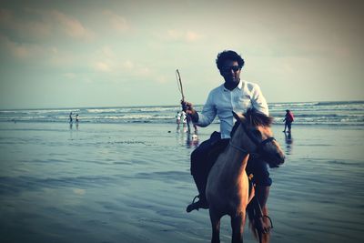 Full length of man standing on beach against sky