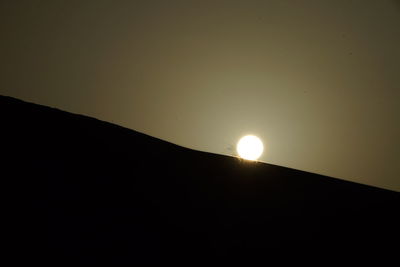 Low angle view of silhouette moon against clear sky at night