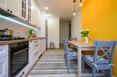 Empty chairs and tables in illuminated room at home