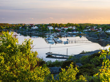 A tranquil summer scene of a harbor in sweden, with boats resting peacefully along the riverbank