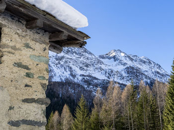 Low angle view of snowcapped mountains against clear sky