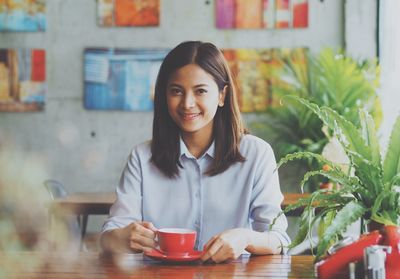 Portrait of young woman sitting at restaurant