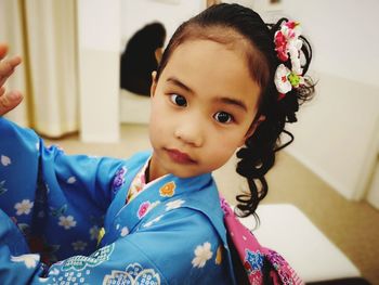 Portrait of cute girl wearing traditional clothing standing at home