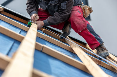 Low section of man standing on wooden wall