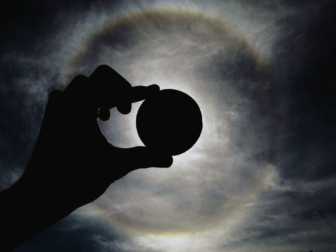 sky, low angle view, cloud - sky, cloudy, cloud, silhouette, dusk, weather, part of, one person, lighting equipment, outdoors, overcast, nature, dramatic sky, close-up, circle, person, sunset, sphere