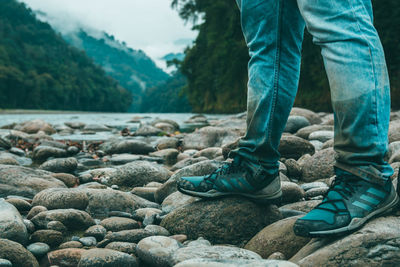 Low section of man standing on rocks