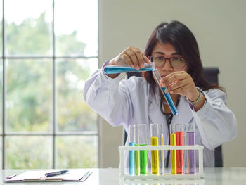 Woman analyzing chemicals in laboratory